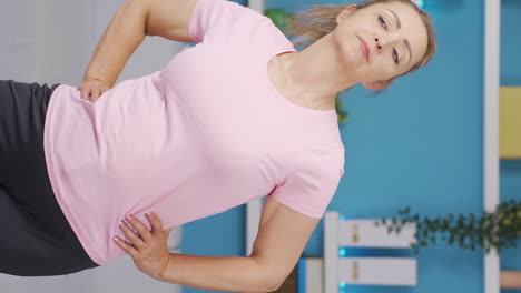 Vertical-video-of-Woman-exercising-at-home.